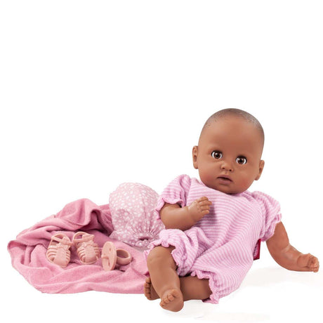 Cosy Aquini baby doll in summer outfit with sandals, headscarf, and hooded towel, holding a pacifier and splash toy