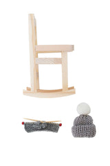 Gemütlicher kleiner Wichtel im Schaukelstuhl mit Strickset und Mützen als skandinavische Weihnachtsdekoration
